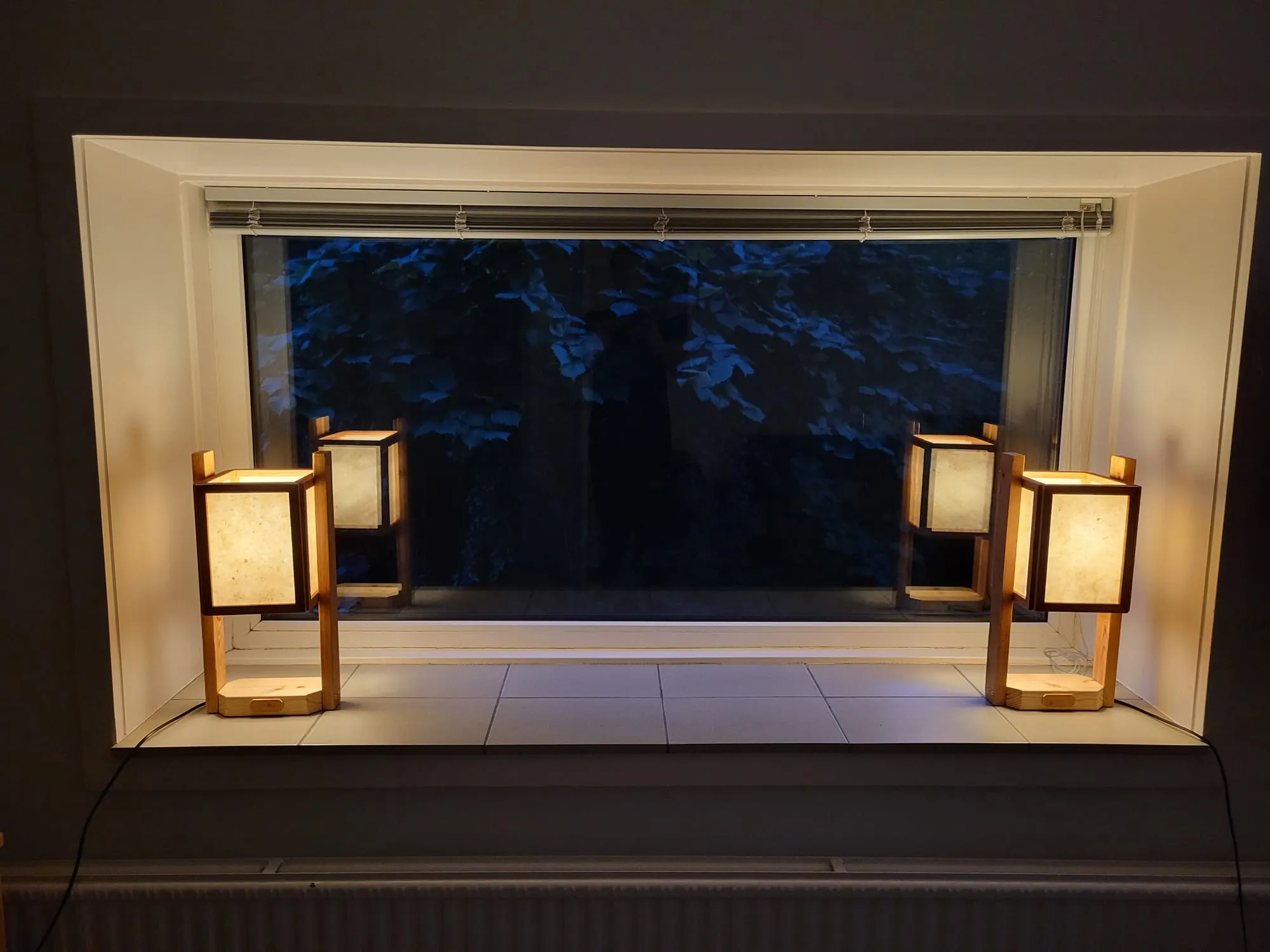 Twee lampen in het raam in het donker